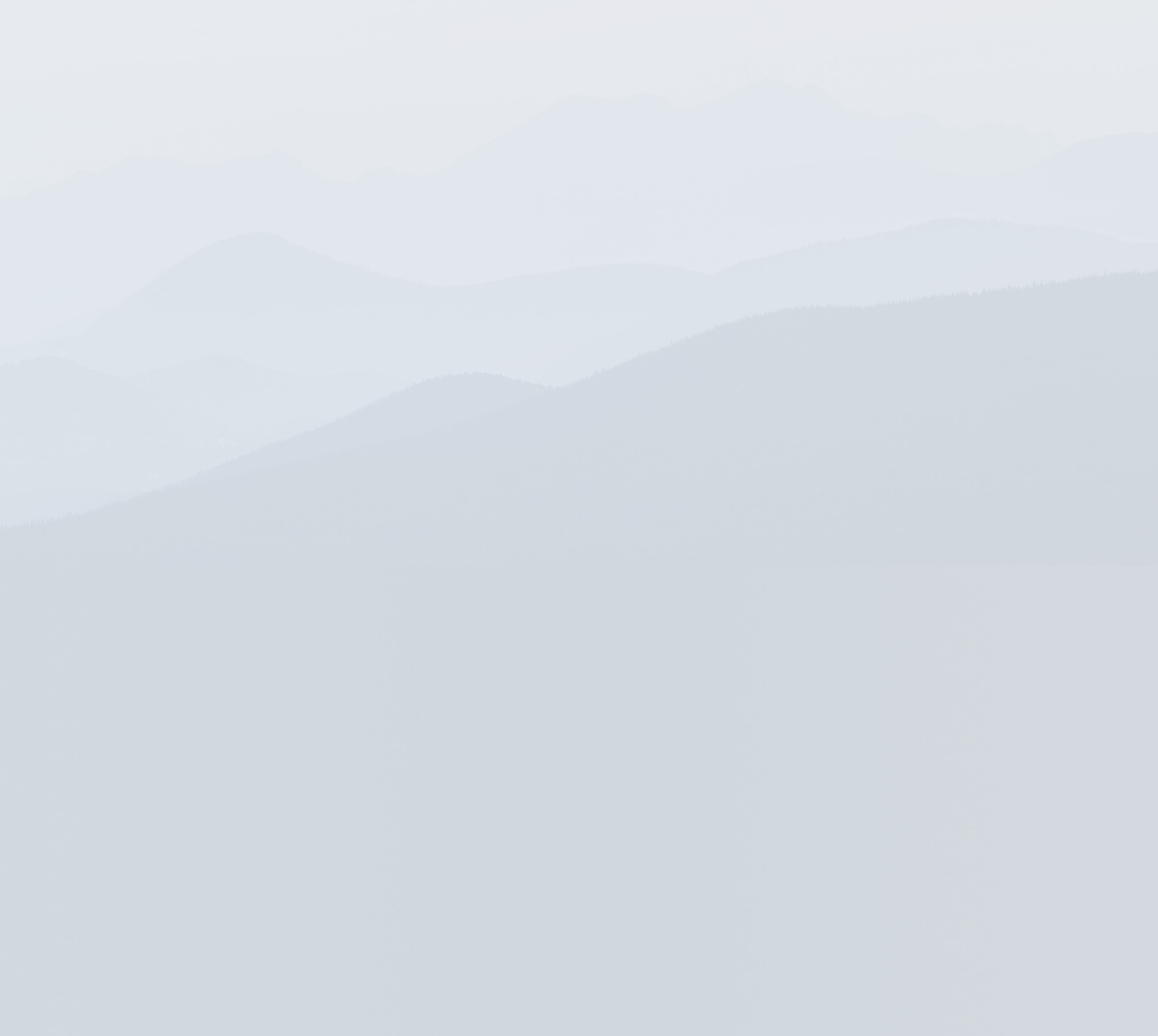 Soft layers of misty blue mountains.