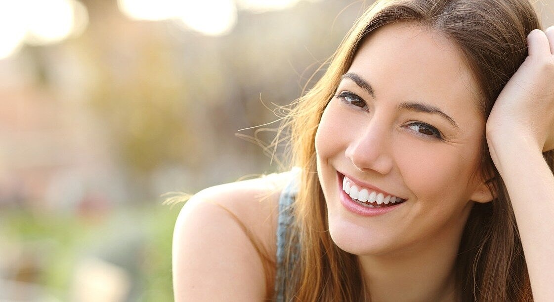 Smiling woman outdoors with natural sunlight.