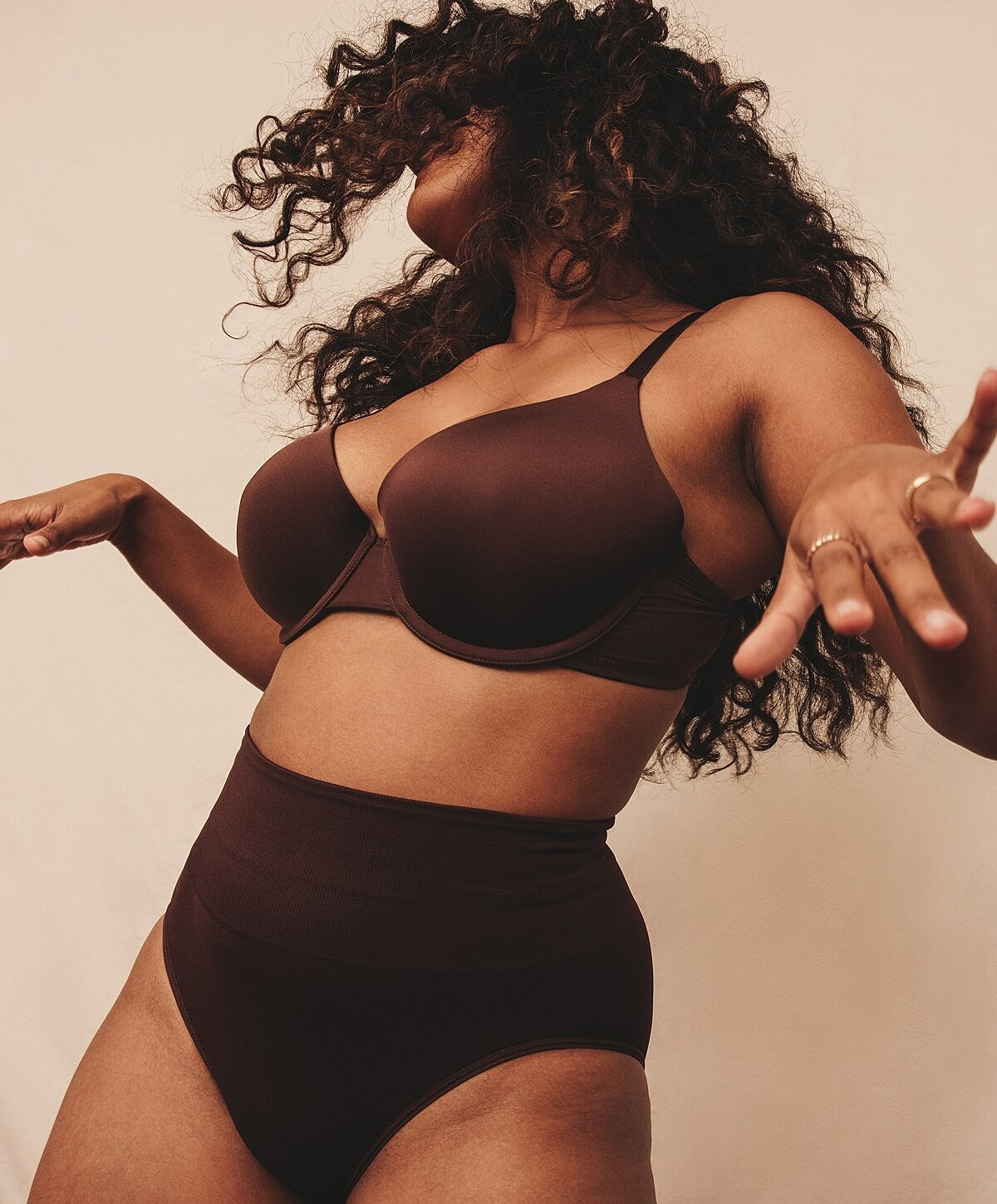 Model in black lingerie showcasing side profile.