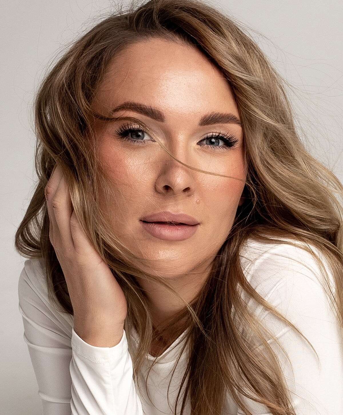 Denver Facial balancing model with long hair in soft lighting.