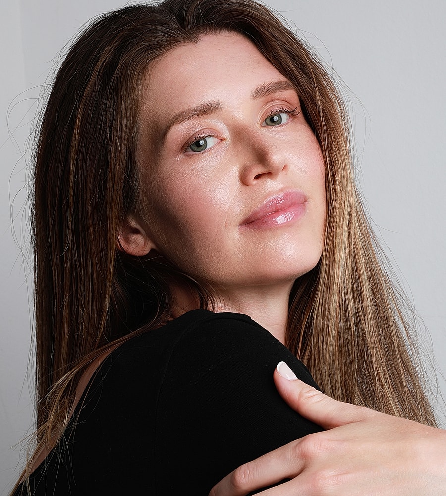 Woman with long hair, smiling softly.