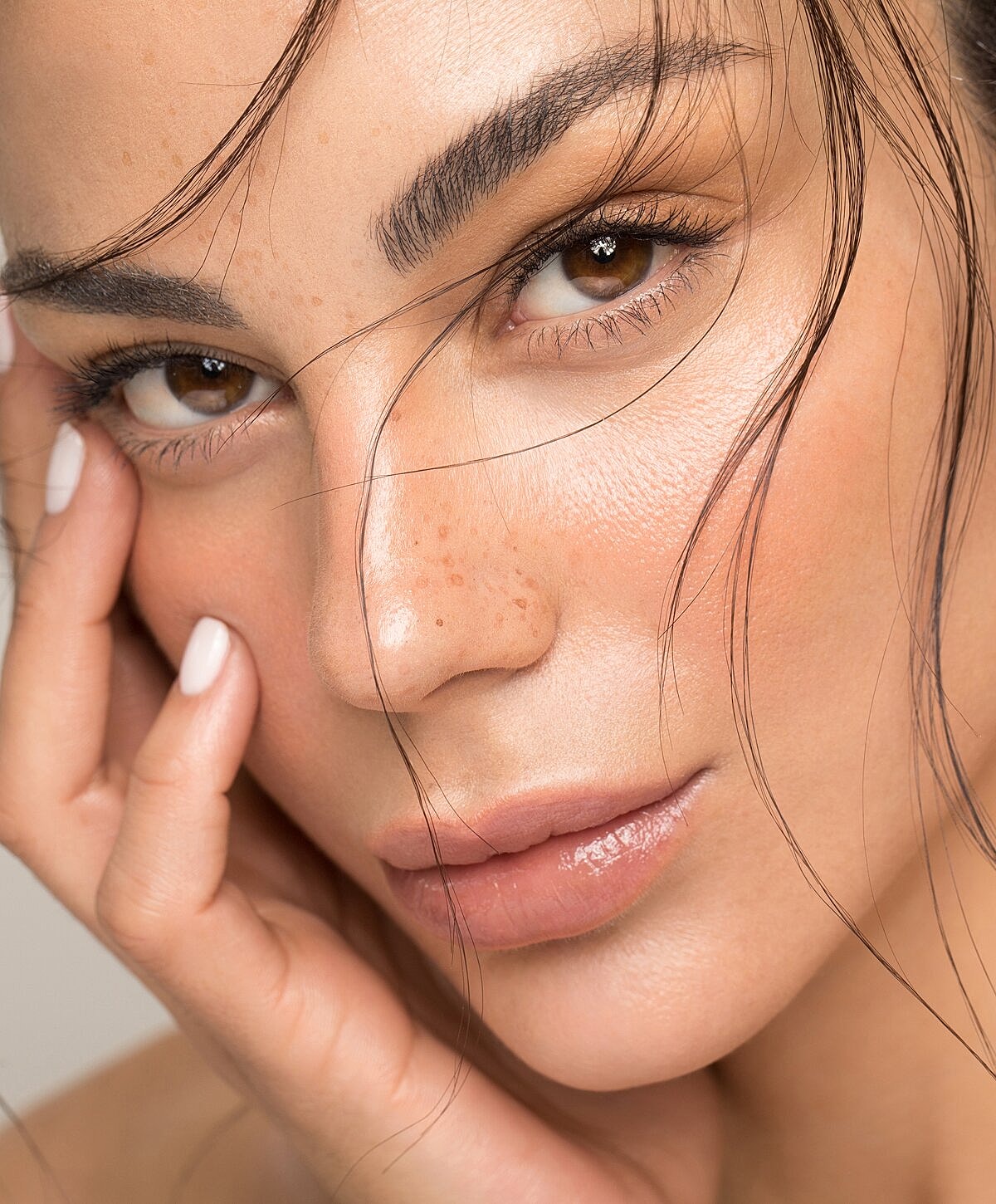 Denver Juvederm model touching her face.