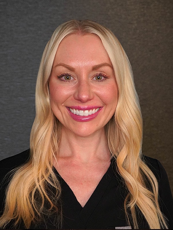 Smiling woman with blonde hair wearing scrubs