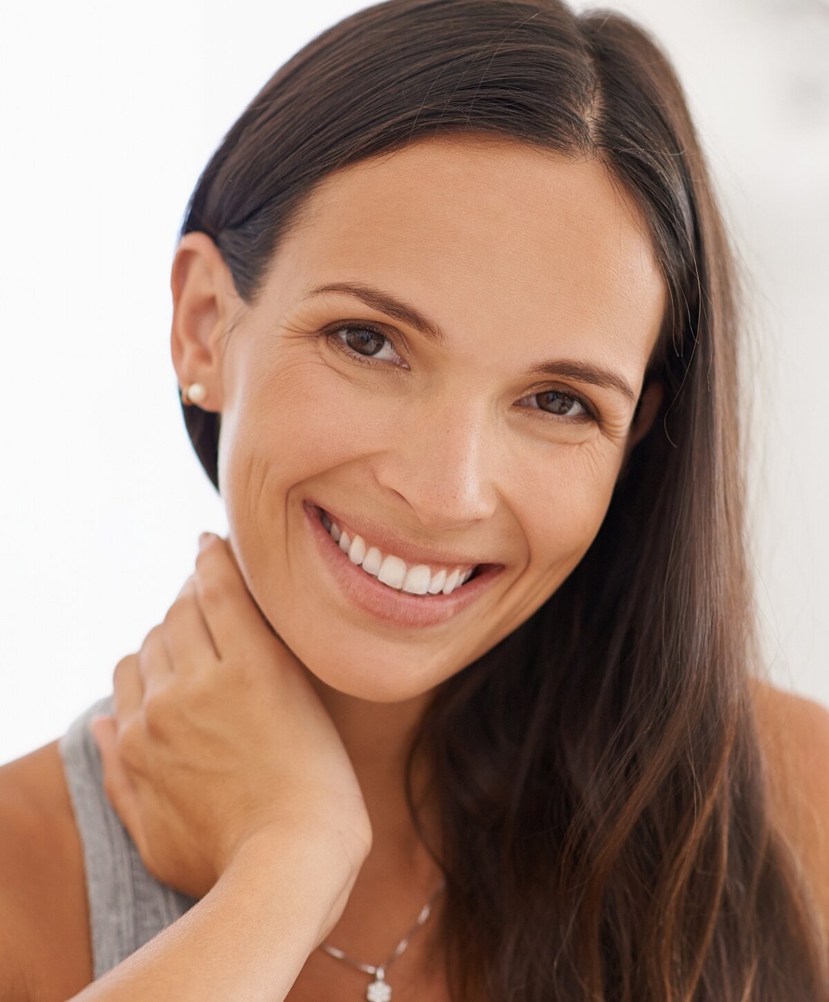 Smiling woman with long hair and necklace.