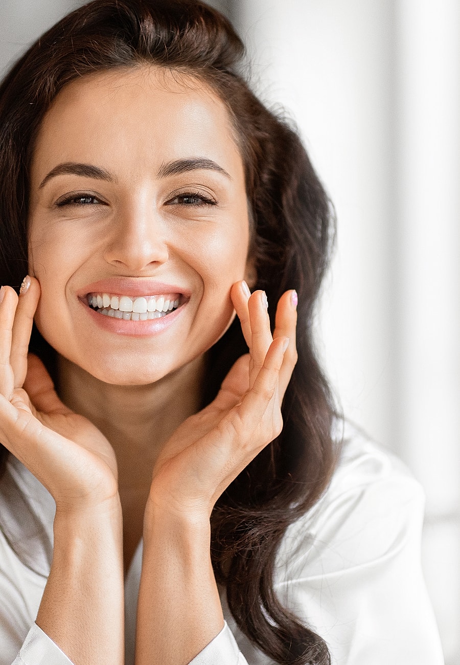 Smiling woman with glossy hair and radiant skin.
