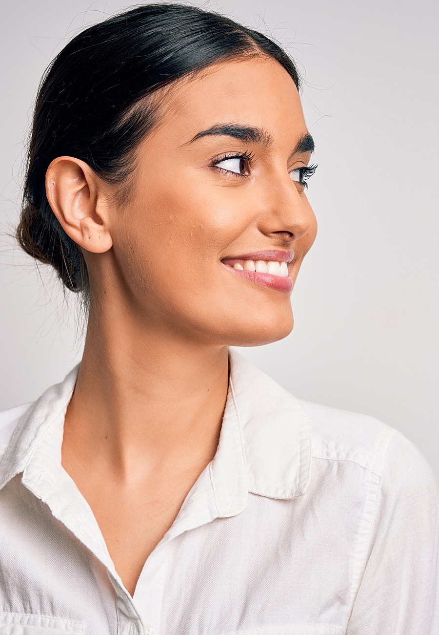 Smiling woman in white shirt, profile view.