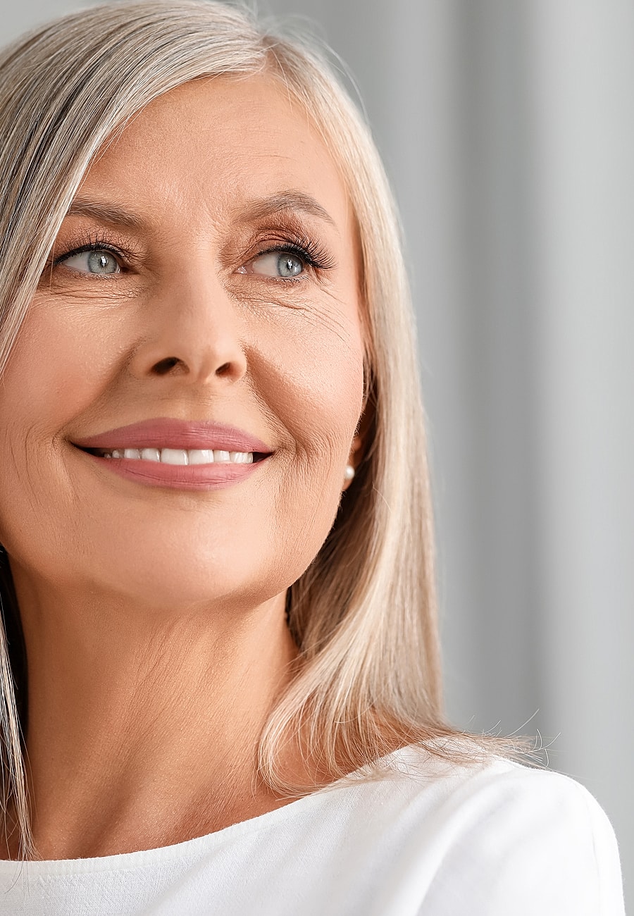 Smiling woman with silver hair and blue eyes.