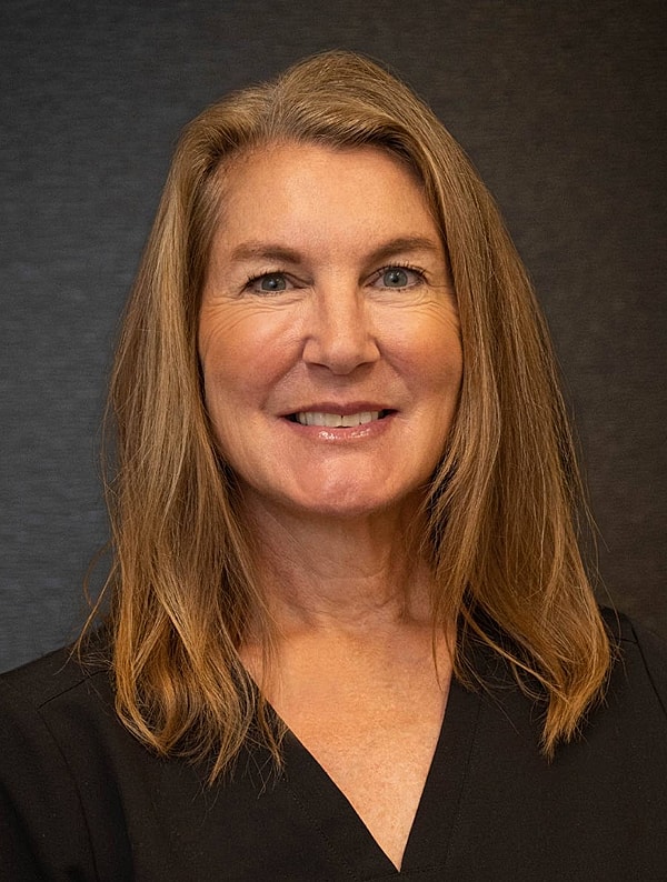 Smiling woman with long hair, black top.