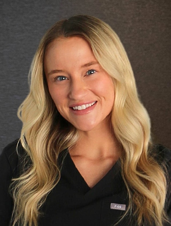 Smiling woman with long blonde hair in scrubs.