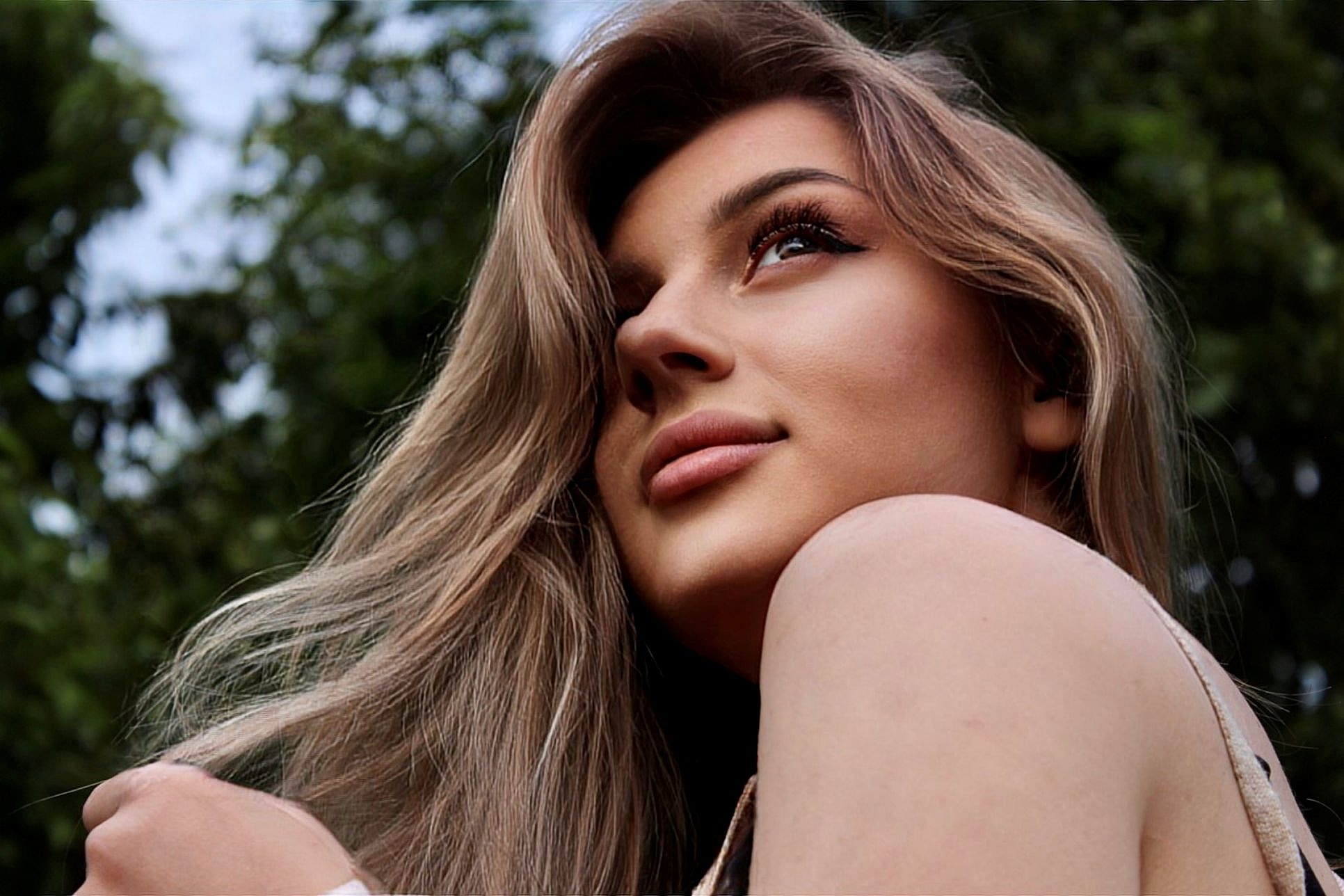 Woman with softly defined facial features outdoors, illustrating facial balancing with dermal fillers for natural-looking results.