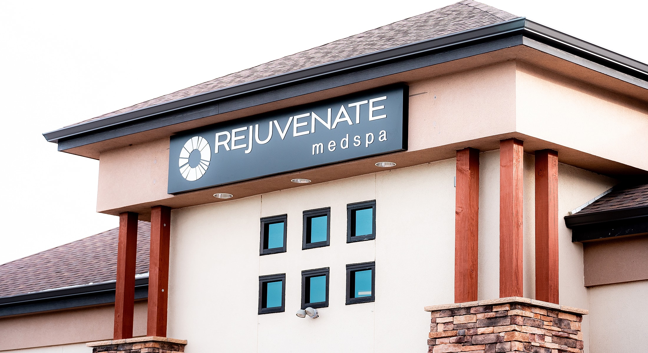 Model in black swimsuit against gray background.