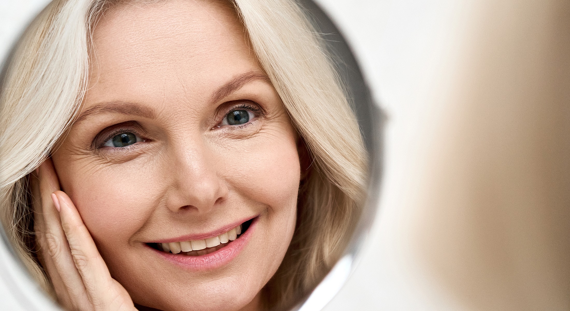 Smiling woman admiring her reflection in mirror.
