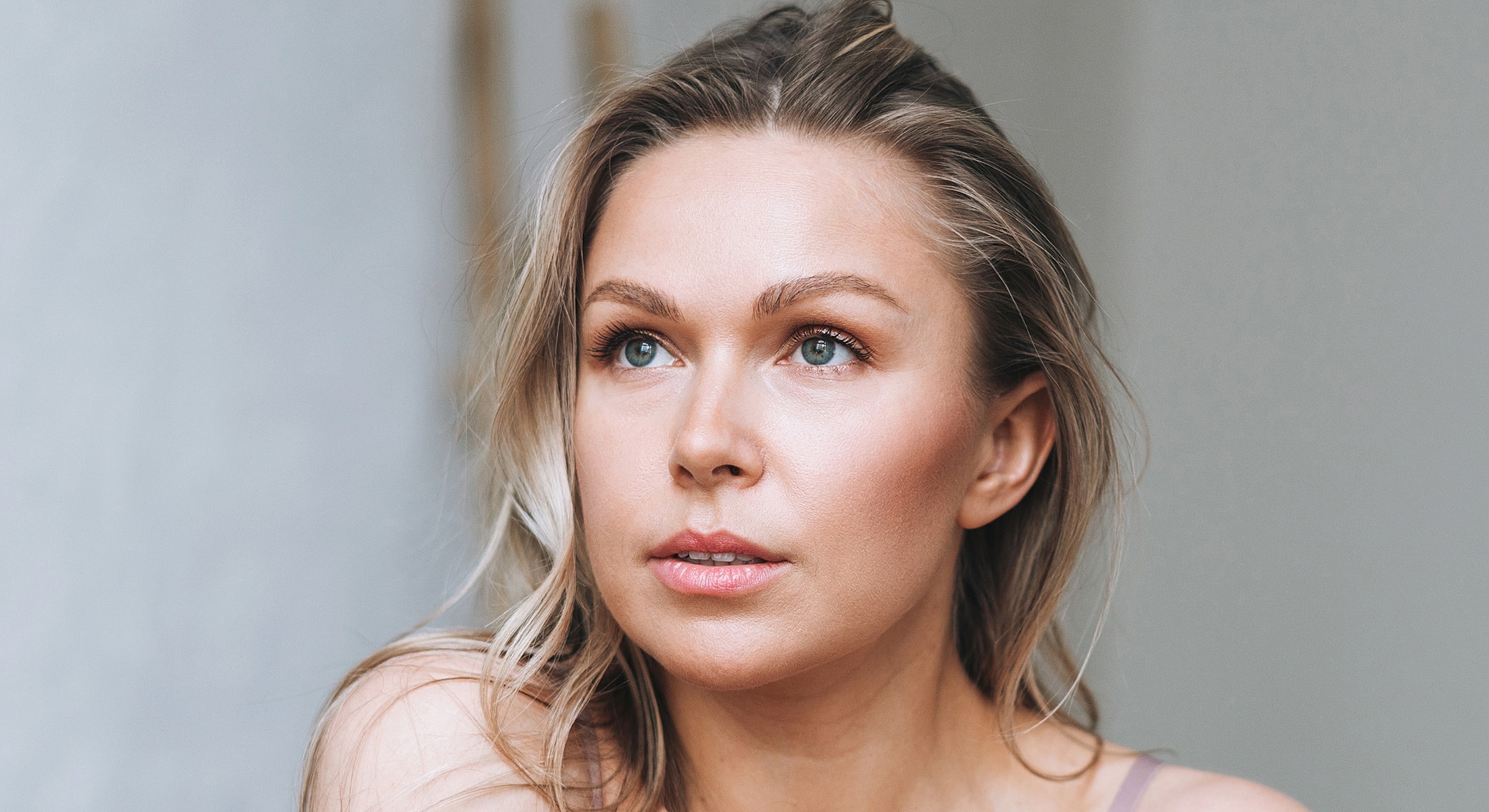 Denver Botox model with blonde hair and blue eyes, thoughtful expression.