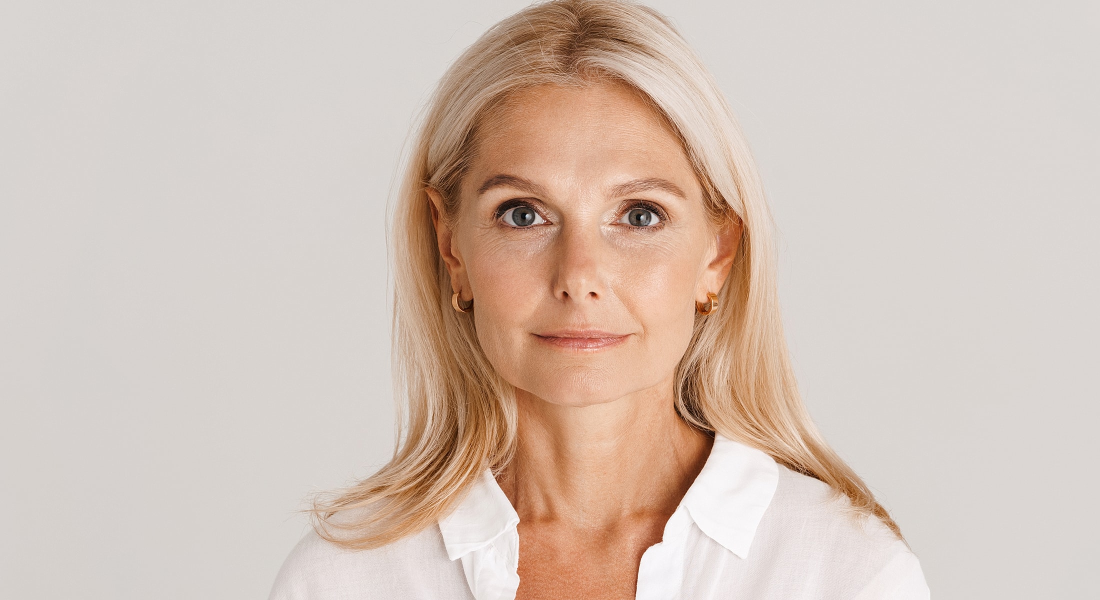Woman with blonde hair in a white blouse.