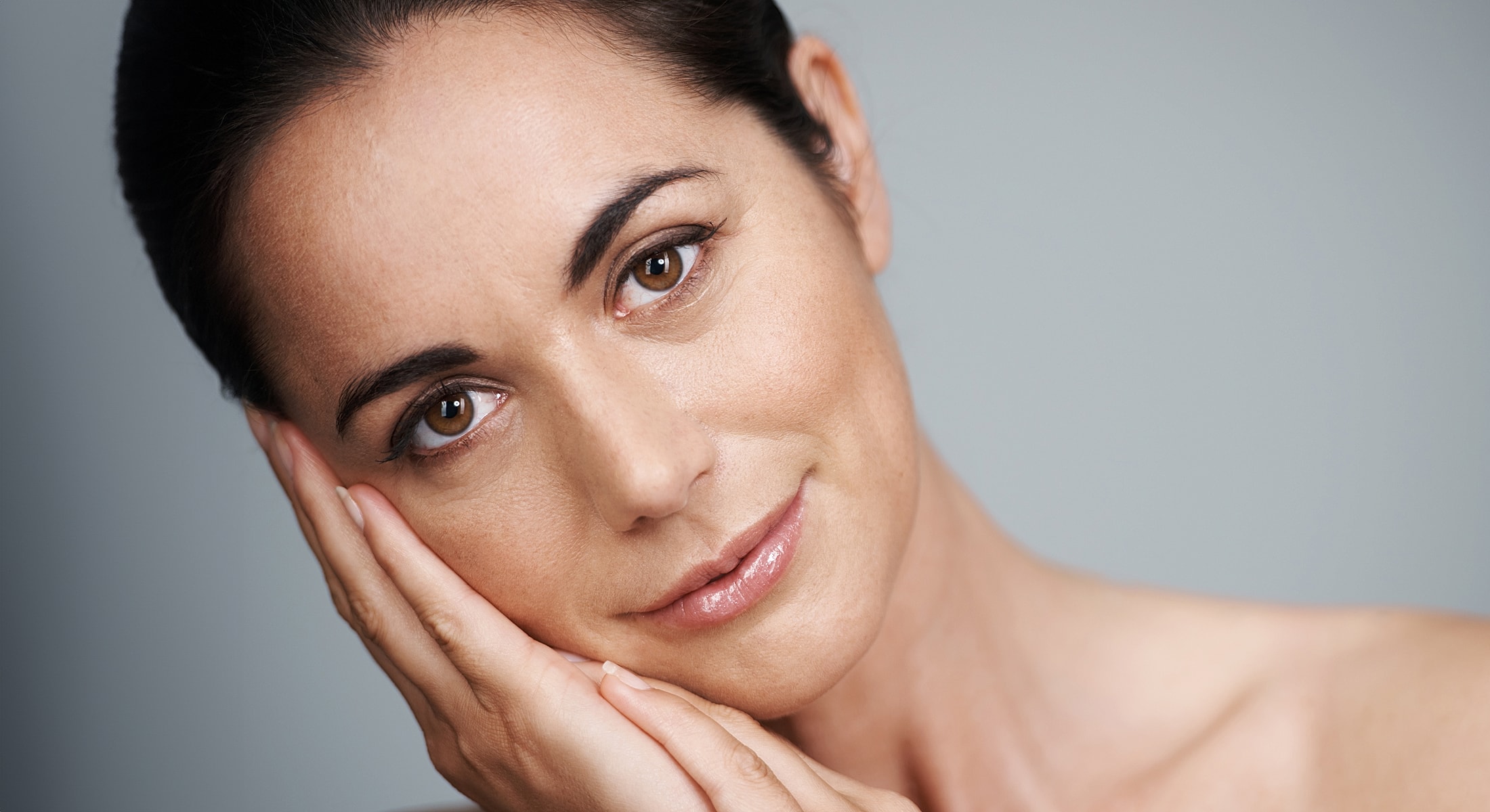 Woman with neutral expression resting her face.