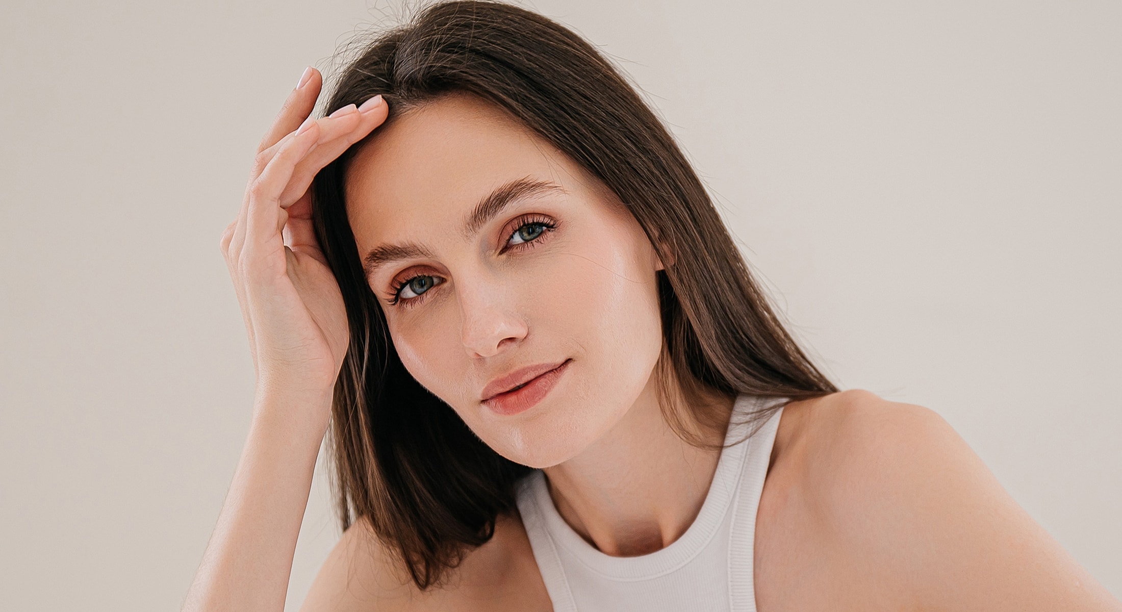 Woman touching her hair, smiling softly.