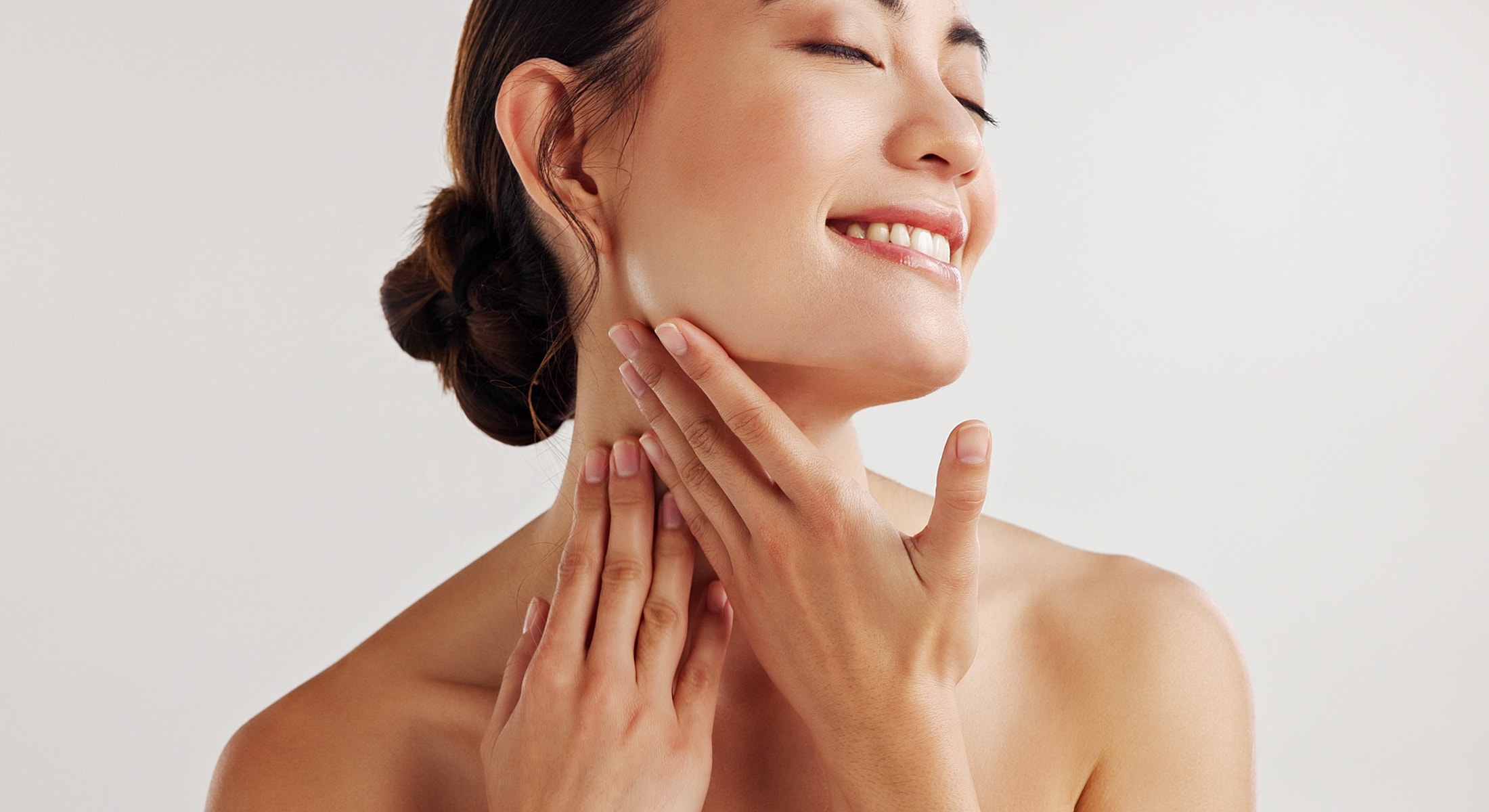Smiling woman with blonde hair against gray background